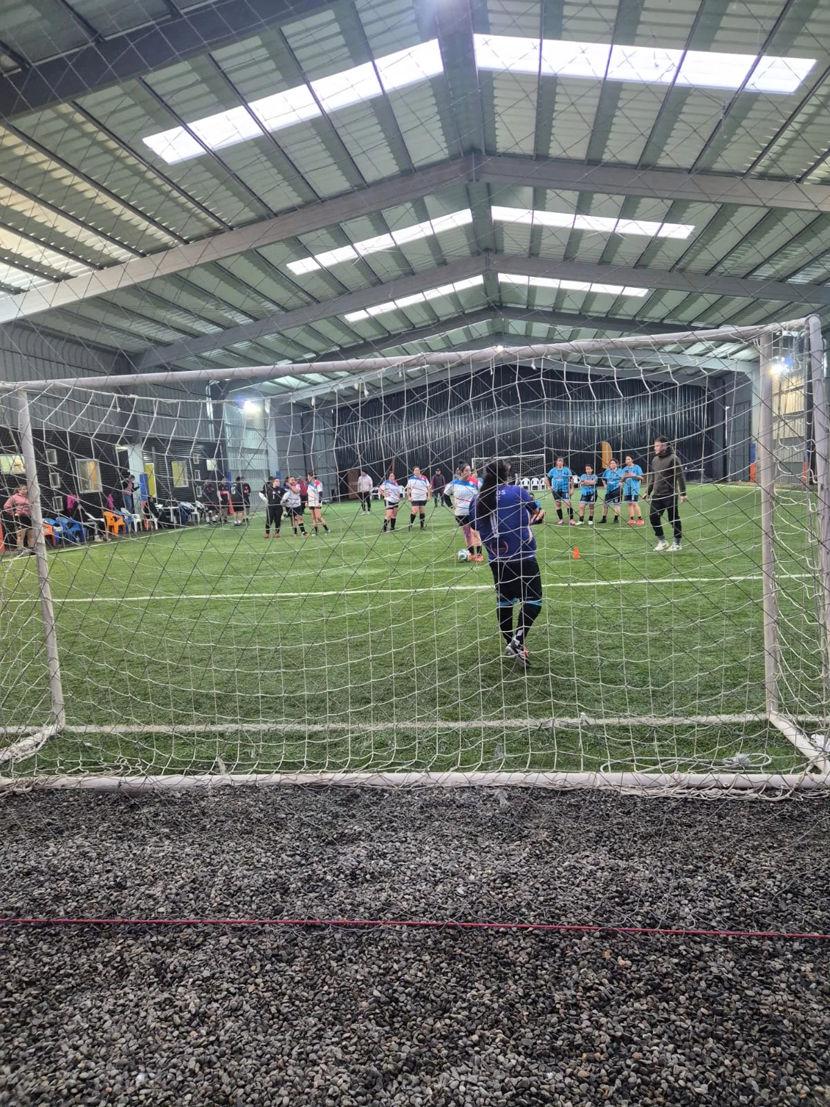 Partido de fútbol visto desde la portería en Club Bahía Sports